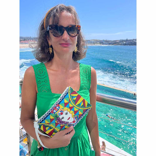 Model in green dress shows Testa Di Moro Clutch Handbag Purse Pochette at Icebergs Bondi Sydney