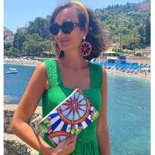 Model in green dress wears DOLCE design purse with blue and white stripes
