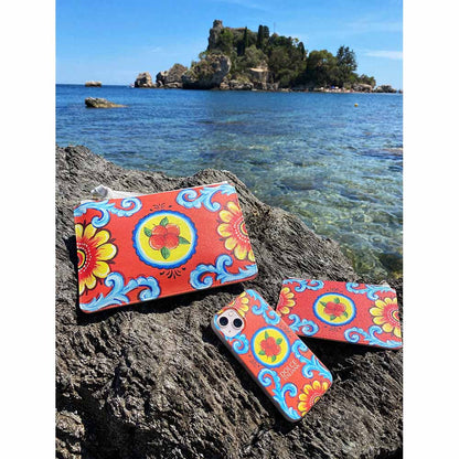 Arancio Piana orange theme phone case and clutch bag in Taormina next to water