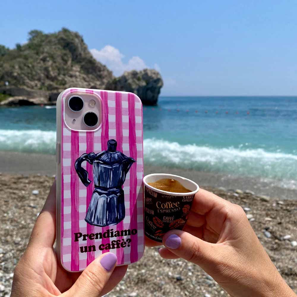 Pink checkered phone cover at beach with coffee