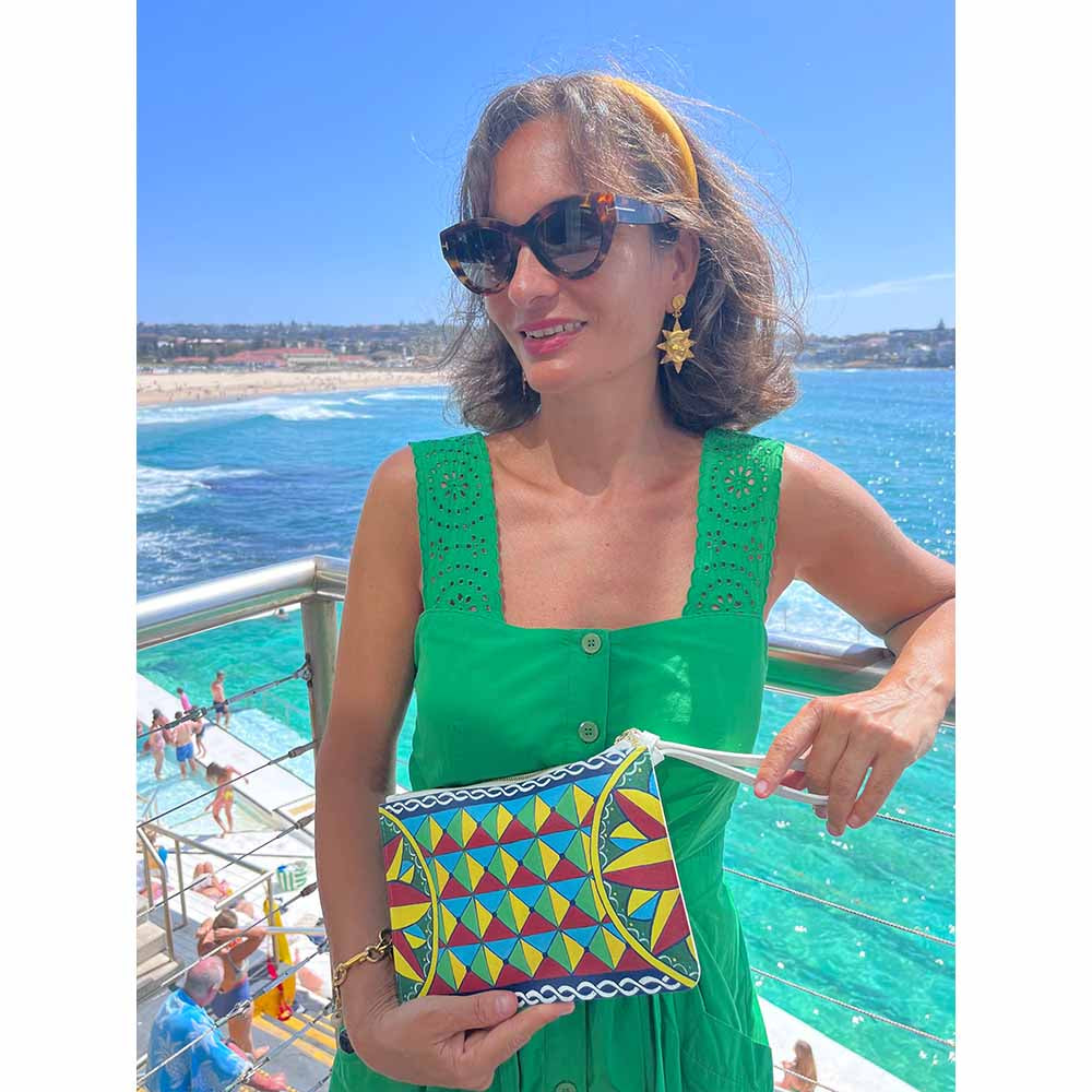 Model wearing handpainted Italian designer handbag at Icebergs Bondi Beach Sydney Australia