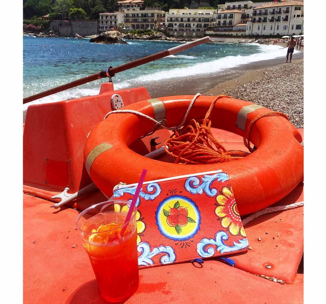 Arancio Piana Clutch bag with an Aperol Spritz on beach in Taormina