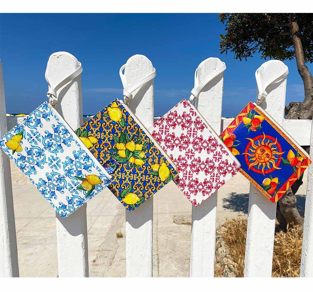 DOLCE ITALIANA clutch bags on fence at Mondell Beach near Palermo Sicily