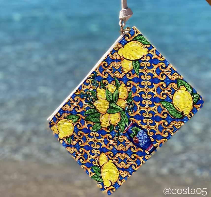 Positano lemon and tile design clutch bag by DOLCE ITALIANA over ocean