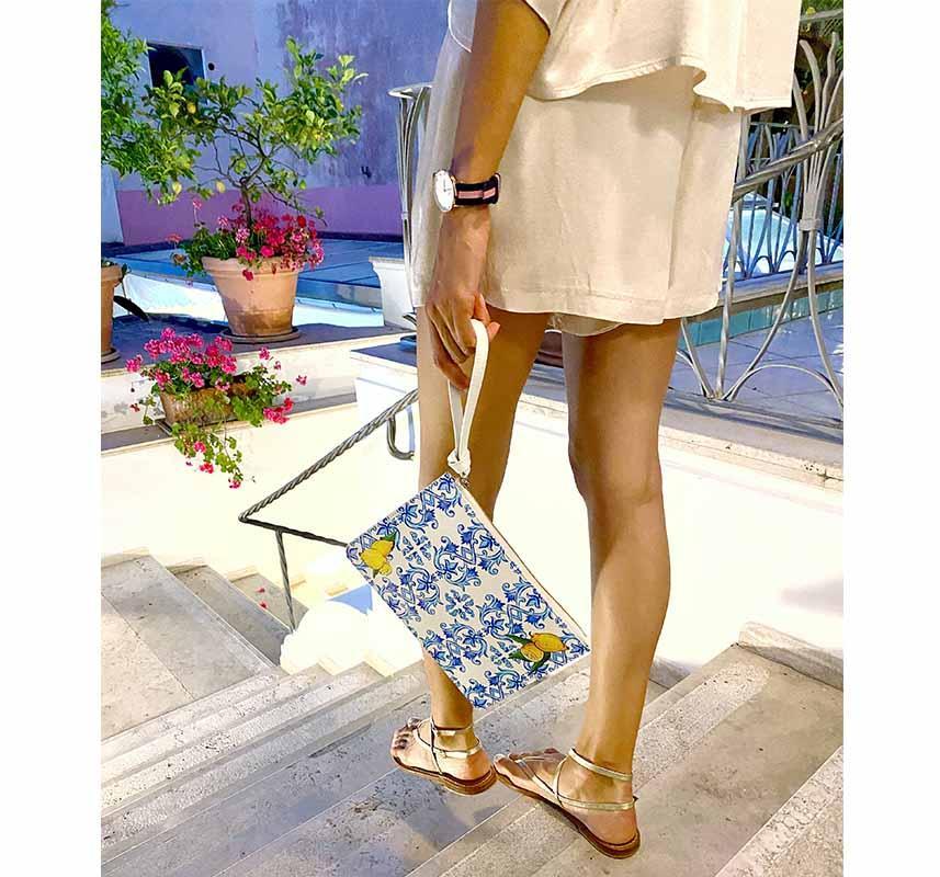 Model wearing stylish lemon and tile design clutch bag by DOLCE ITALIANA