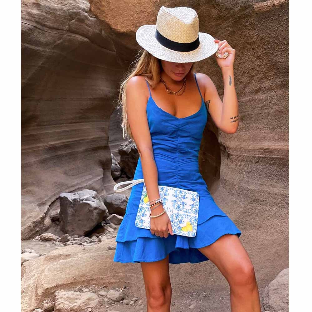 Capri Clutch Bag with lemons and blue maiolica tile design worn by model in blue dress